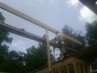 Carpenter setting a ridge beam over a new addition frame — Ice Dam Removal by Roofing Brothers in Hot Springs National Park