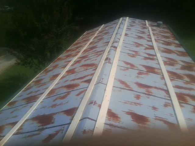 Rusted metal roof panels with new wood purlins before replacement — Storm Damage Roof Repair in Hot Springs National Park by Roofing Brothers